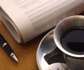 Showing pen, newspaper and coffee cup